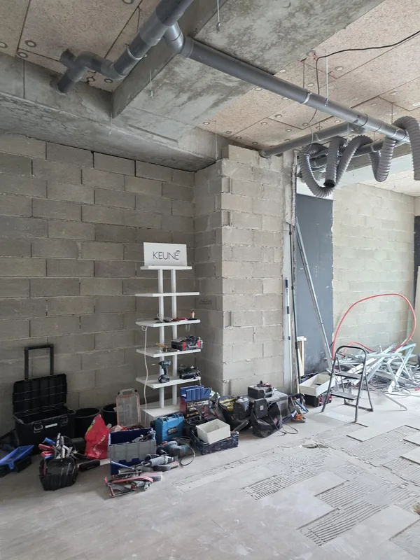 Local avant travaux : gros œuvre en parpaings apparent et gaines au plafond, avant le tirage des câbles électriques
