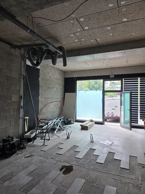Local avant travaux, vue sur la devanture vitrée, sol posé mais réseau électrique pas encore réalisé